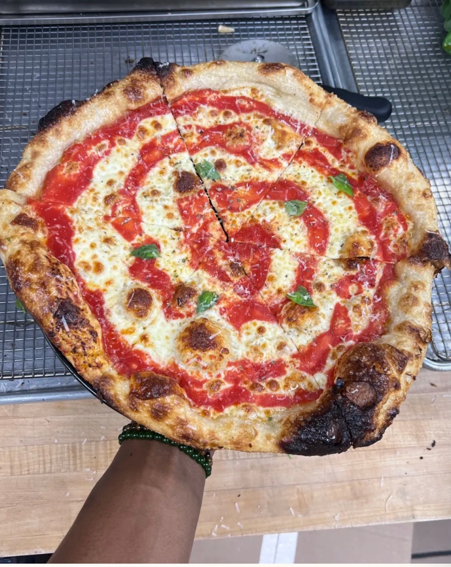 A New York cheese pizza with a spiral of sauce and leoparded crust